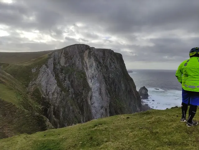 a person standing on the Sturrall cliffs overlooking the ocean