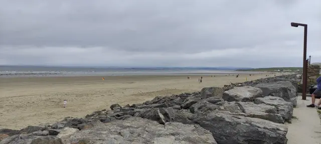 a rocky beach with people walking on it