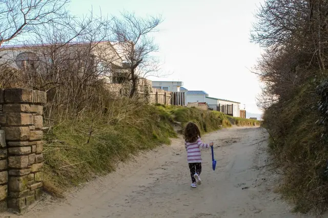 a girl walking down a dirt road