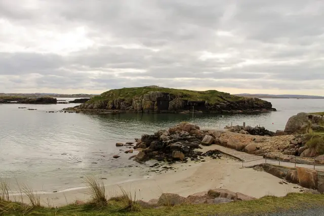 a rocky beach with a hill in the background