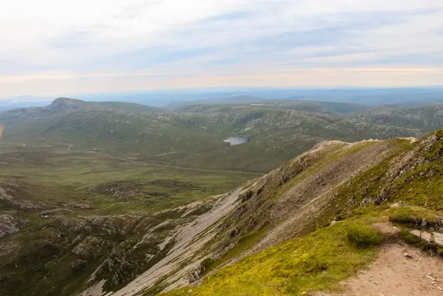 a landscape with hills and a body of water in the distance