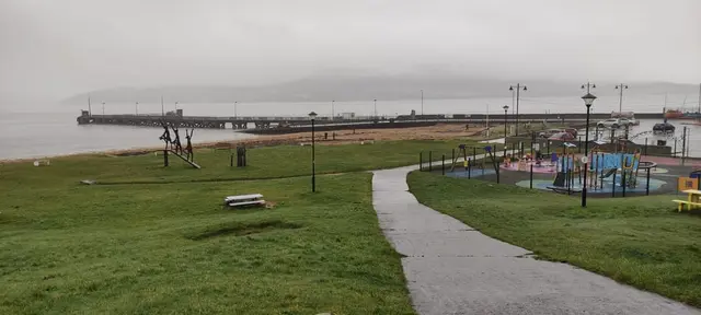 a body of water with grass and a walkway by it
