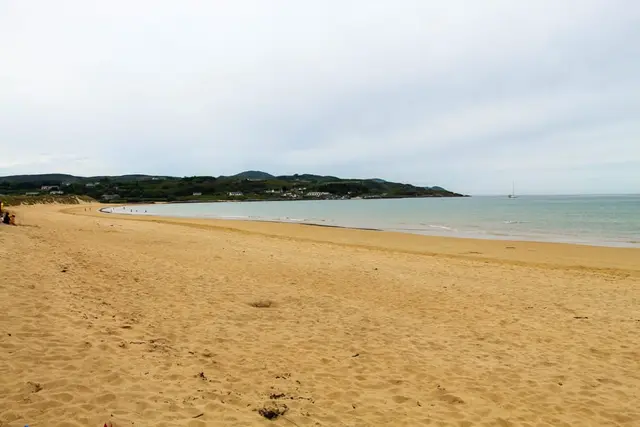 a sandy beach with a body of water in the background