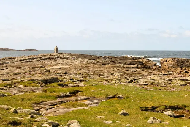 a rocky beach with a lighthouse