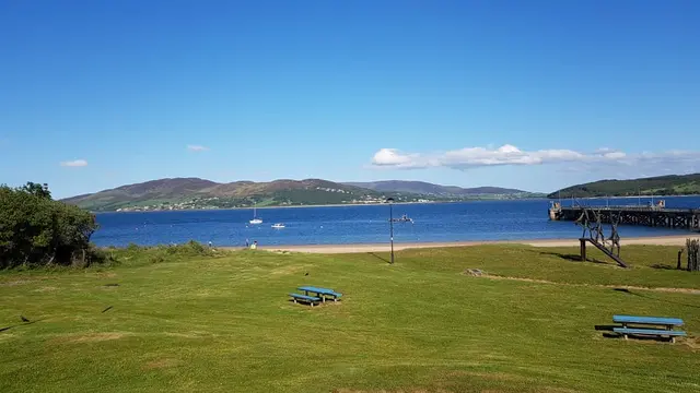 a grassy area with a body of water in the background