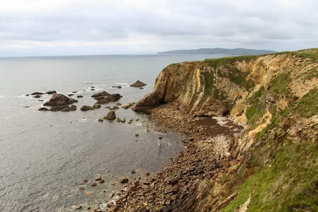 a rocky beach with a large body of water in the background