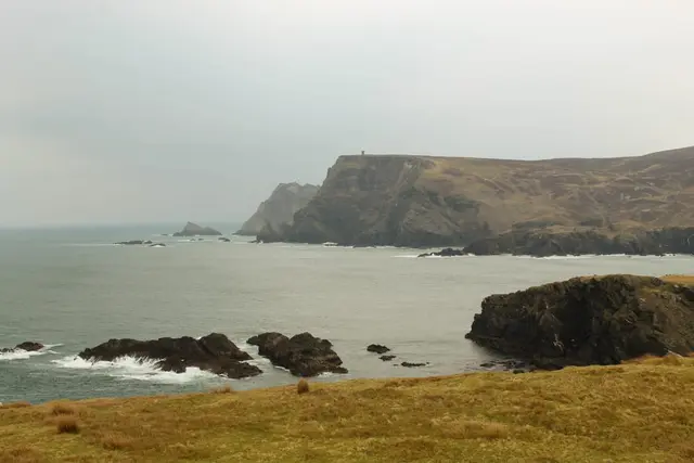 a rocky beach with a large body of water in the background