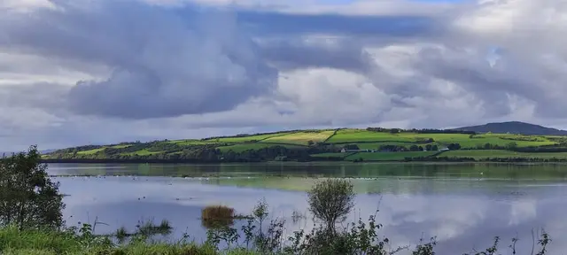 a body of water with hills in the background