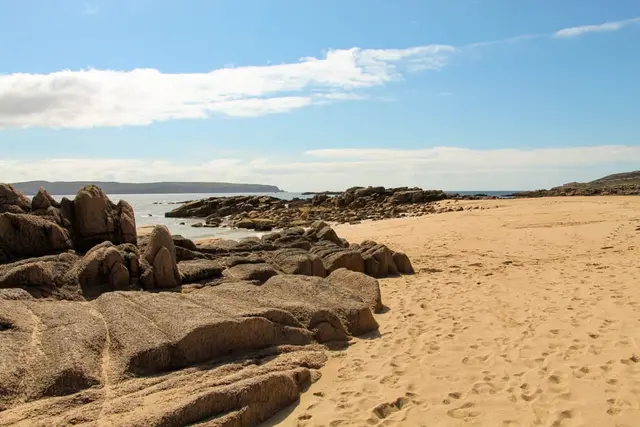 a sandy beach with rocks