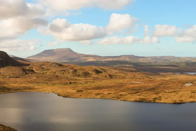 a body of water with hills in the back