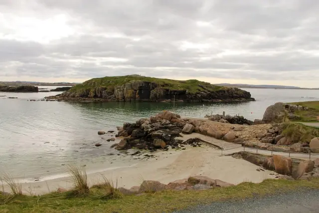 a rocky beach with a hill in the background