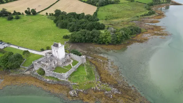 a castle on a cliff by a river