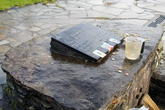 a bucket of water on a stone surface