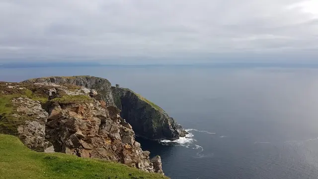 a cliff with a body of water below