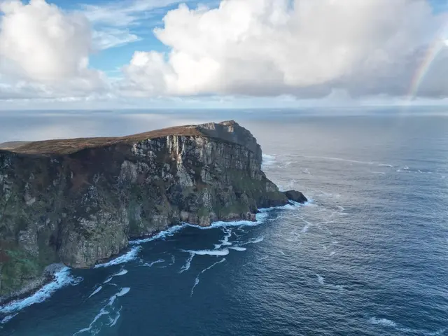 a cliff with a rainbow