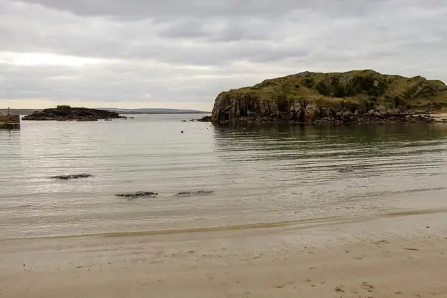 a beach with a hill in the background