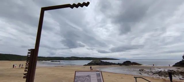a beach with people and a sign