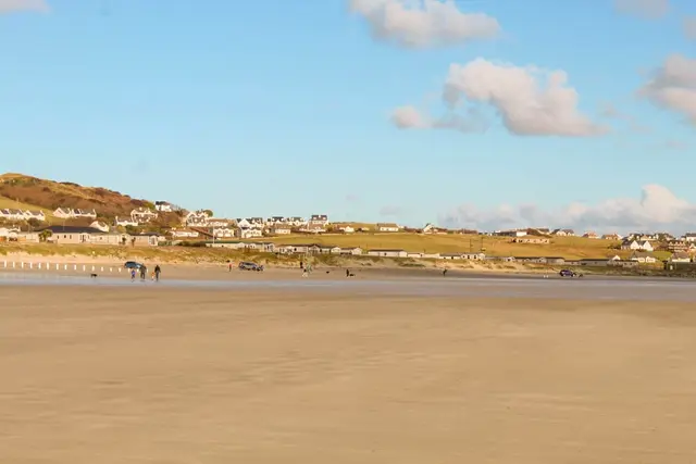 a beach with people and cars