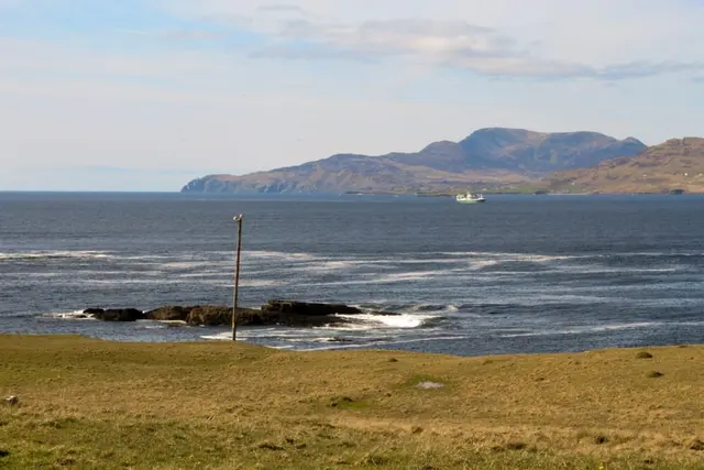 a body of water with rocks and a pole in the middle