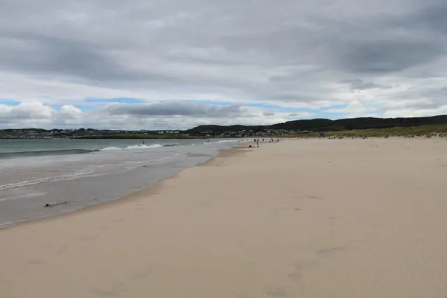 a beach with people walking on it