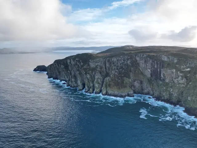 a rocky cliff next to a body of water