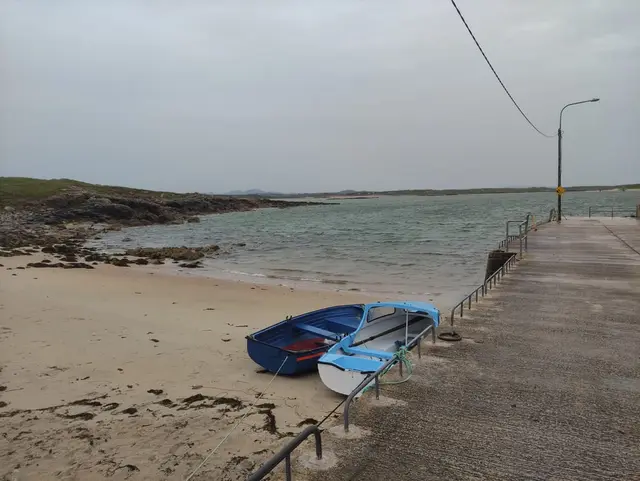 boats on the beach and a small pier next to the Gola Island pier