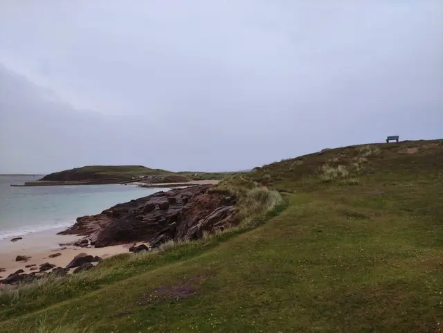 a grassy hill overlooking the Magheragallan beach