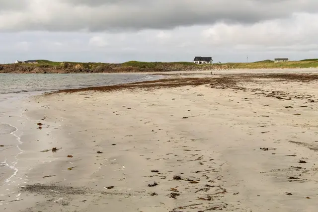 a beach with a house in the distance